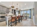 Open kitchen boasts a large island, gray cabinets, bar stool seating and stainless appliances at 10011 Secluded Gdn Dr # 169, Apex, NC 27523