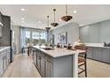 Stunning kitchen with gray cabinets, quartz countertops, pendant lighting, and stainless appliances at 10011 Secluded Gdn Dr # 169, Apex, NC 27523