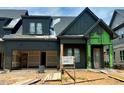 New home construction featuring dark siding, a two-car garage and covered porch with modern design elements at 1027 Coldspring Circle, Durham, NC 27705