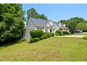 Single-Gathering home with a lush lawn, mature trees, and a concrete driveway at 106 Gumdrop Path, Apex, NC 27502