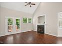 Bright Living room with a ceiling fan, fireplace, and French doors to the deck at 106 Gumdrop Path, Apex, NC 27502