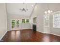 Living room with a ceiling fan, fireplace, hardwood floors, and French doors to deck at 106 Gumdrop Path, Apex, NC 27502