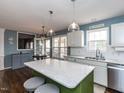 Bright kitchen boasts stainless steel appliances, pendant lighting, and a green island with seating at 1100 Open Field Dr, Garner, NC 27529