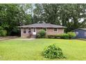 A well-kept brick home boasts a lush green lawn and mature trees at 1219 Lakeland St, Durham, NC 27701