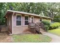 Close-up of brick home showcasing a cozy front porch and shuttered windows at 1219 Lakeland St, Durham, NC 27701
