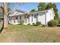 White brick one-story home with green lawn, gray shutters and front wooden porch columns at 1246 Nc-27, Benson, NC 27504