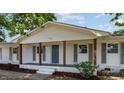 A charming front porch with sturdy wooden columns and a painted blue front door of this one-story home at 1246 Nc-27, Benson, NC 27504