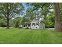 Beautifully landscaped white brick home with a well-manicured lawn and mature trees offering privacy at 132 Edgewood Dr, Louisburg, NC 27549