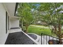 Inviting front porch with black textured flooring and black railings, offering a serene outdoor space at 132 Edgewood Dr, Louisburg, NC 27549