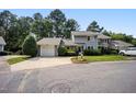 Charming townhome with a well-manicured lawn, attached garage, and a private driveway surrounded by mature trees at 1600 Budwood Dr, Raleigh, NC 27609
