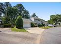 Well-maintained townhome featuring an attached garage and landscaped front yard in a serene, tree-lined neighborhood at 1600 Budwood Dr, Raleigh, NC 27609