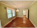 Inviting dining room featuring hardwood floors, a chandelier, and a window with natural light at 1609 Cypress Dr, Henderson, NC 27536