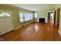 Bright living room features hardwood floors, large windows, and a fireplace with a white mantel at 1609 Cypress Dr, Henderson, NC 27536