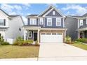 Charming two-story home featuring blue siding, stone accents, and a spacious two-car garage at 1725 Winter Jasmine Ln, Wake Forest, NC 27587