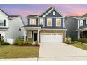 Charming two-story home showcasing navy siding, brick accents, and a spacious driveway at 1725 Winter Jasmine Ln, Wake Forest, NC 27587