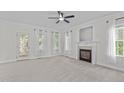 Spacious living room with a cozy fireplace, neutral carpet, and multiple windows for natural light at 188 Worthington Ct, Clayton, NC 27527
