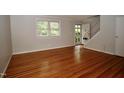 Open-concept living room boasting hardwood floors, light gray walls, and stairway at 1908 Smallwood Dr, Raleigh, NC 27605