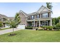 Charming brick home with a well-maintained lawn, inviting front porch, and lush landscaping at 2100 Della Ct, Apex, NC 27502