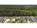 Aerial view of the home with a large wooded area behind the property, offering privacy and a sense of nature at 2329 Field Poppy Dr, Apex, NC 27502