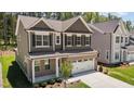 Charming two-story home featuring a brick facade, a two-car garage and manicured lawn at 2329 Field Poppy Dr, Apex, NC 27502