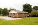 Rear exterior of brick home featuring a well-maintained yard at 250 Patterson Dr, Roxboro, NC 27573