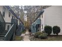 View of condos within a complex, with individual entrances and stairs. Bushy landscaping is shown between each building at 311 Ashley Forest Rd # Bldg E, Chapel Hill, NC 27514