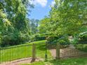 Serene backyard with lush greenery, an iron fence, and colorful flowers creating a peaceful retreat at 3307 Devon Rd, Durham, NC 27707