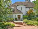 Charming front entrance with brick steps leading to a wood door, complemented by manicured landscaping at 3307 Devon Rd, Durham, NC 27707