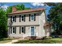 Charming two-story home with light siding, black shutters, brick entryway, and manicured yard at 3317 E Jameson Rd, Raleigh, NC 27604