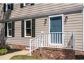Close up of the front of the house with blue door, white railings, and green lawn at 3317 E Jameson Rd, Raleigh, NC 27604