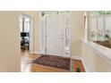 Bright foyer featuring wood floors, a white front door with sidelights and transom, and a decorative area rug at 3928 Bentley Bridge Rd, Raleigh, NC 27612