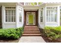 Welcoming home entrance with brick steps leading to a bright green front door framed by beautiful bay windows at 3928 Bentley Bridge Rd, Raleigh, NC 27612