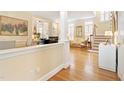 Elegant living room featuring hardwood floors, a staircase and a glimpse of the fireplace, and lots of natural light at 3928 Bentley Bridge Rd, Raleigh, NC 27612