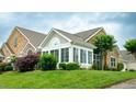 A sunroom awash in natural light has large windows and lush surrounding landscaping at 425 Faith Dr, Gibsonville, NC 27249