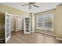 Bright bedroom with a ceiling fan, wood flooring, and double doors leading to an additional room at 5910 Giddings St, Raleigh, NC 27616