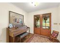 Foyer features piano, area rug, and double doors with wreath, creating a warm and inviting entrance at 6517 Whitted Rd, Fuquay Varina, NC 27526