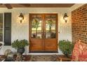 Charming front entrance featuring double doors adorned with wreaths and decorative plants, enhancing curb appeal at 6517 Whitted Rd, Fuquay Varina, NC 27526