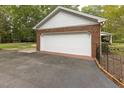 Spacious detached garage with a white door and brick siding, offering ample parking space at 6517 Whitted Rd, Fuquay Varina, NC 27526