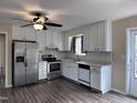 Well-lit kitchen with stainless steel appliances, white cabinets, and wood-look floors at 803 Flat Rock Church Rd, Louisburg, NC 27549