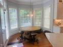 Breakfast nook featuring an inviting round table with a pendant light fixture and bay windows at 8729 Valentine Ct, Raleigh, NC 27613