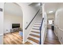 Inviting entryway with hardwood floors, staircase, and a view into the living room at 930 Pristine Ln, Rolesville, NC 27571