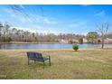 Scenic lake view with a bench, trees, and homes in the distance at 930 Pristine Ln, Rolesville, NC 27571