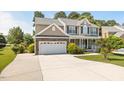 Two-story home with neutral siding, stone accents, attached garage, and a wide concrete driveway at 947 Middle Ground Ave, Rolesville, NC 27571