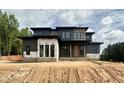 Modern home featuring a sleek design, dark siding, large windows, and a contemporary architectural style at 10 Gambel Dr, Youngsville, NC 27596