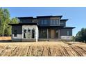 New modern home features clean lines, dark siding and a contemporary design with a bright front door at 10 Gambel Dr, Youngsville, NC 27596