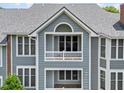 A close up exterior view of the condominium showing the grey siding, roofing, and charming balcony at 1061 Wirewood Dr # 303, Raleigh, NC 27605