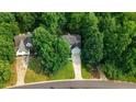 Aerial view of a charming two-story home with lush green trees and a long driveway at 1128 Neuse Ridge Dr, Clayton, NC 27527