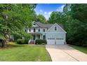 Inviting two-story home featuring a covered porch, a two-car garage, and a beautifully landscaped front yard at 1128 Neuse Ridge Dr, Clayton, NC 27527