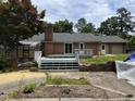 Backyard showcasing a brick house with a wooden deck and a sprawling lawn at 1208 Hatch Rd, Chapel Hill, NC 27516