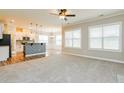 Bright living room with carpet floors, lots of natural light, and an open floor plan leading to the kitchen at 123 Pleasant View Ln, Benson, NC 27504